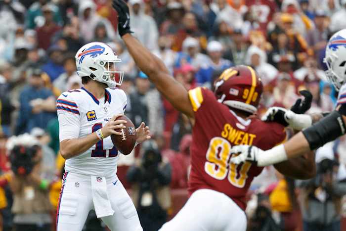 Josh Allen looks downfield as Washington's Montez Sweat attempts to find his team's first sack of the game.